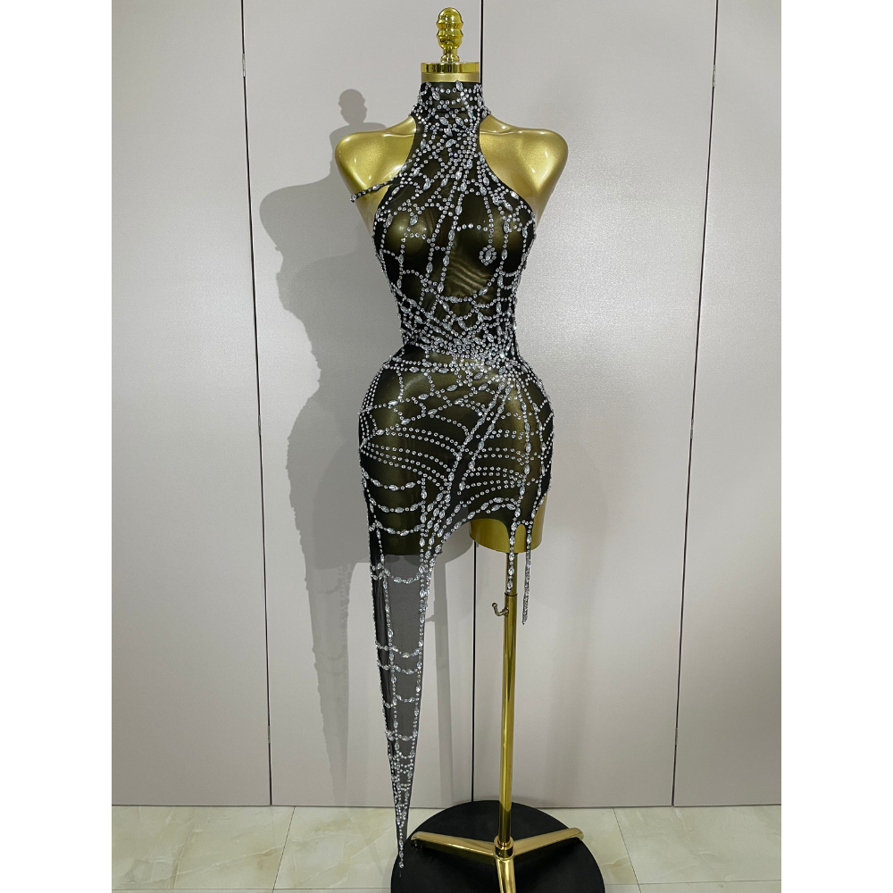 Black dress with silver embellishments on a gold mannequin against a white wall. Black dress with silver embellishments on a gold mannequin against a white wall.