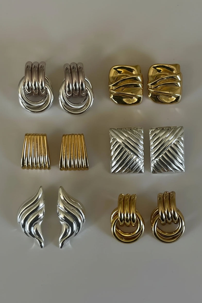 Collection of gold and silver earrings on a light gray background Main image