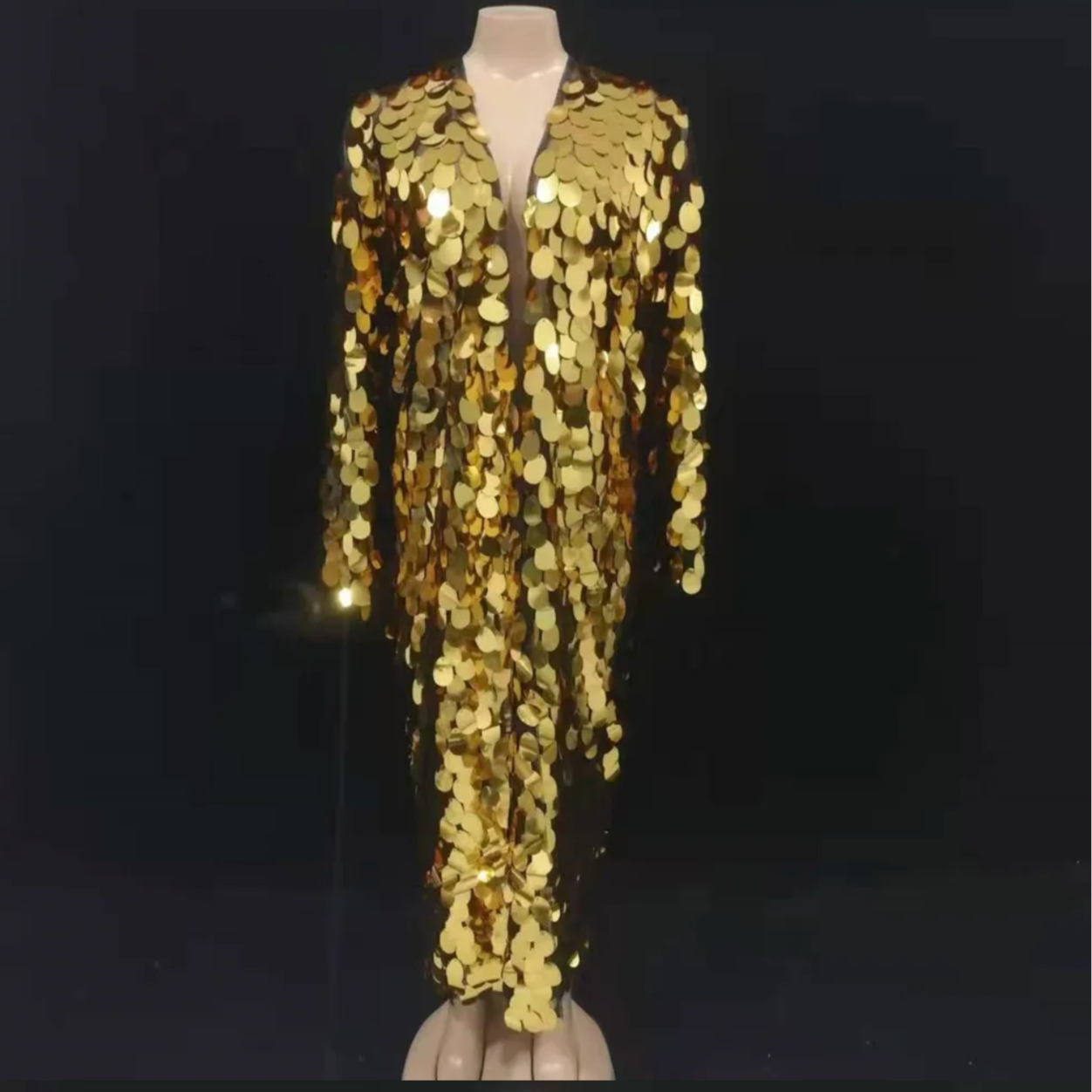Mannequin wearing a gold sequin outfit against a black background