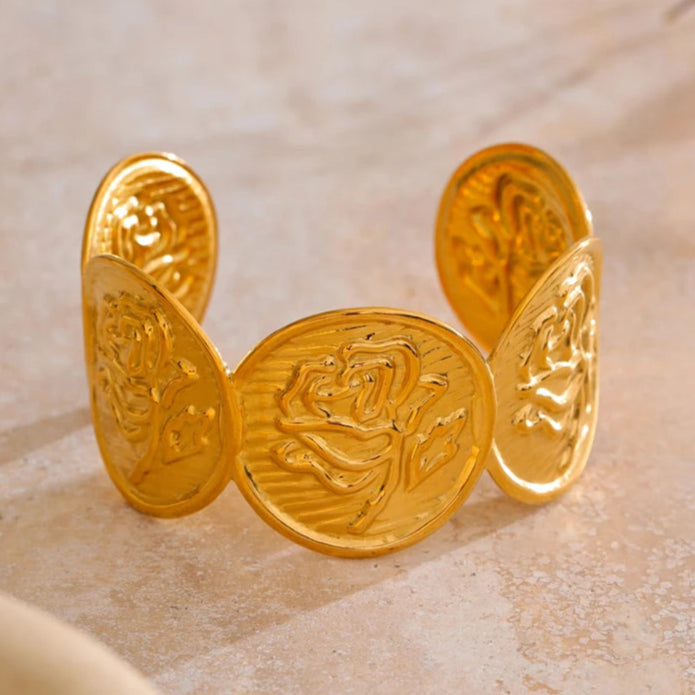Gold coin bracelet on a marble surface