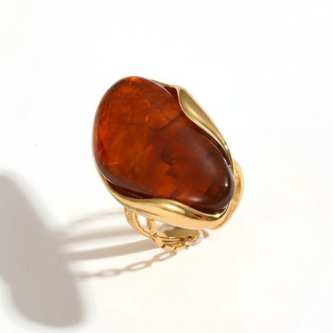 Gold ring with a large brown stone on a white background