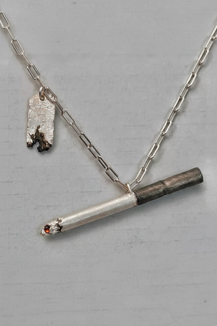 Silver necklace with a unique pendant on a gray background Image principale du produit