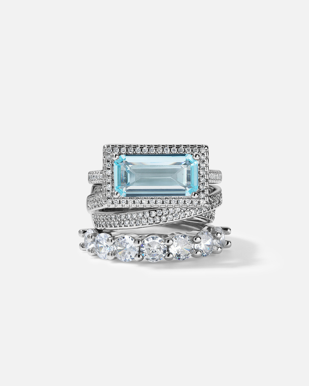 Set of three rings with a blue gemstone and diamond accents on a light gray background