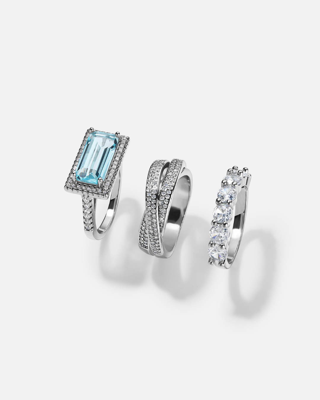 Three silver rings with gemstones on a white background