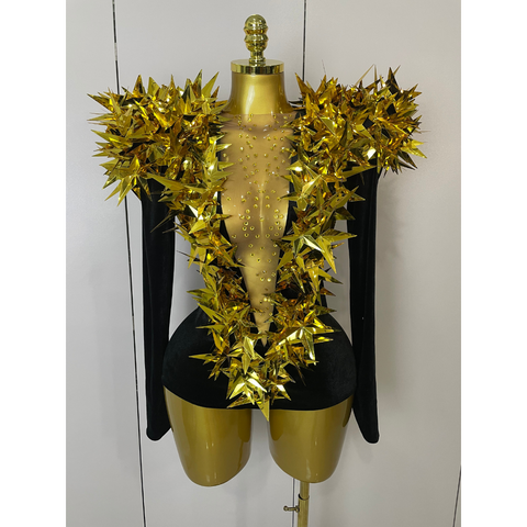 Mannequin wearing a gold outfit with decorative elements on a white background