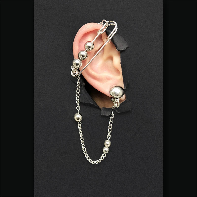 Silver ear cuff with spherical beads and chain on a black background