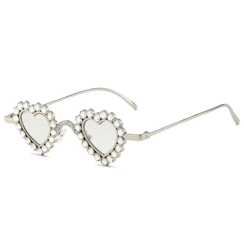 Sunglasses with heart-shaped lenses and decorative frame on a white background