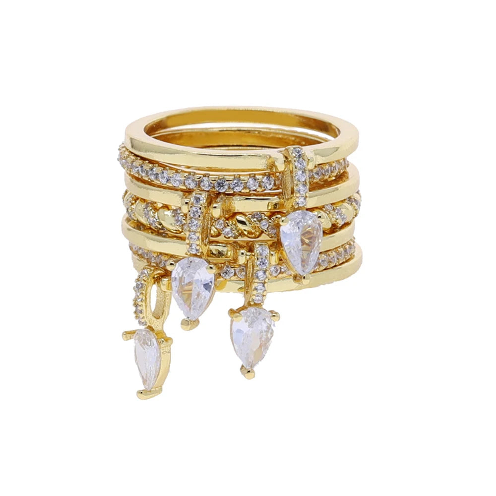 Stack of gold rings with teardrop-shaped gemstones on a white background
