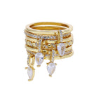 Stack of gold rings with teardrop-shaped gemstones on a white background
