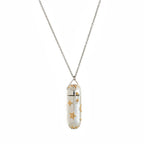 Necklace with a capsule pendant featuring gold stars on a white background